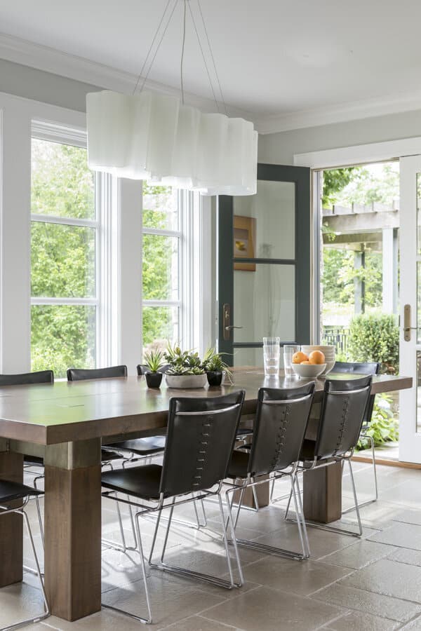 Modern dining room with stylish furniture and pendant lighting.