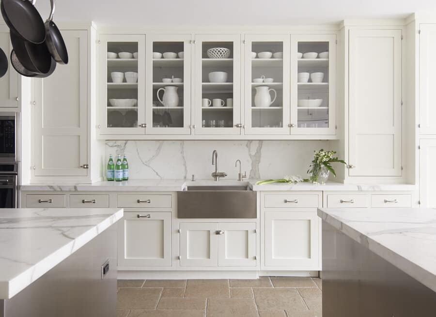 Elegant white kitchen interior with marble countertops.