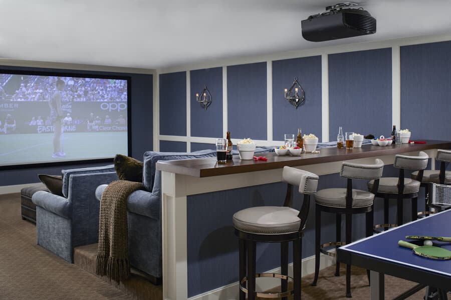 Home theater room with ping pong table and bar seating.