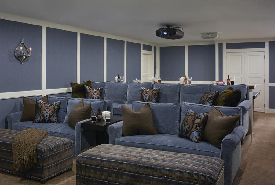 Modern home theater room with plush seating and projector.