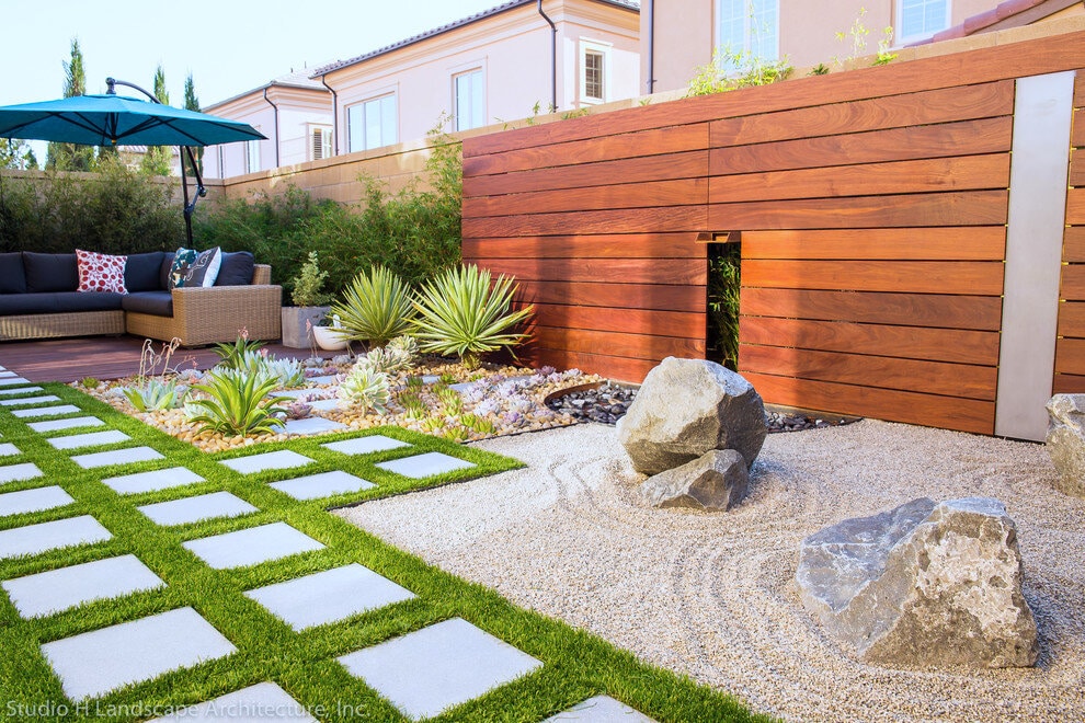 Modern backyard garden with wooden fence and landscaping.