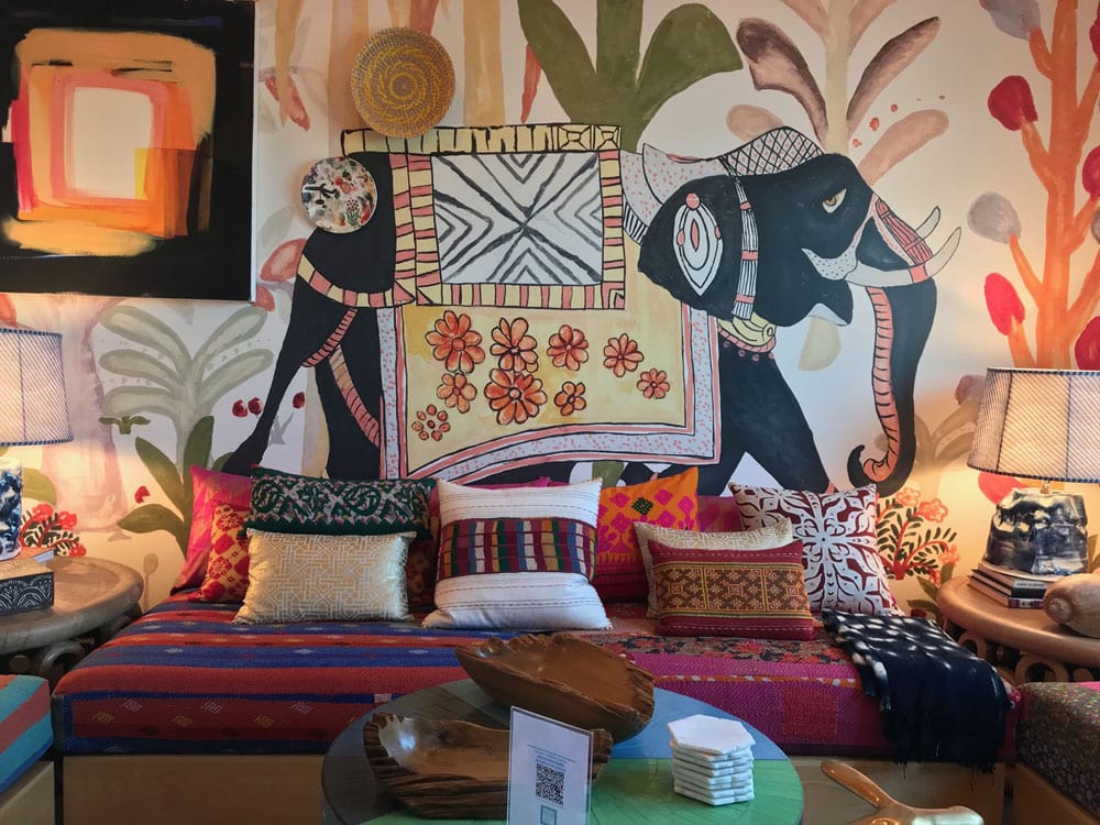 Colorful ethnic-style interior with decorative mural and textiles.