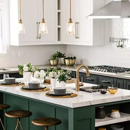 Modern kitchen with green cabinetry and gold accents.