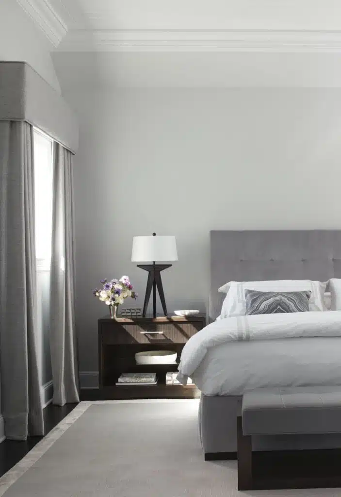 bedroom with gray headboard and white linens